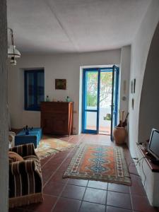 een woonkamer met een bank en een glazen schuifdeur bij Villa TERRA in Oliena