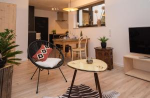 a living room with a table and chairs and a television at Art of living Mosel in Longuich