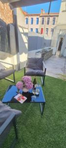 patio z 2 ławkami i stołem na trawie w obiekcie Maison de ville avec garage w mieście Prades