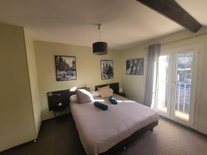 a bedroom with a large bed and a window at Hostellerie de Rimplas in Rimplas