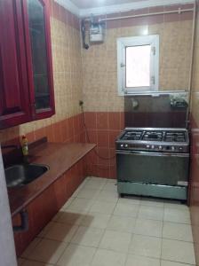a small kitchen with a stove and a sink at خالد بن الوليد بجوار كشرى التحرير in Alexandria