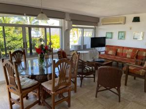 a dining room and living room with a table and chairs at Hotel Villas Los Angeles in Manzanillo