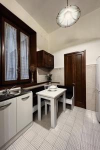 uma cozinha com uma mesa, um lavatório e um frigorífico em Da Mario in Florence Guesthouse em Florença