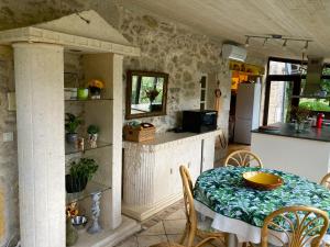 eine Küche und ein Esszimmer mit Tisch und Stühlen in der Unterkunft Galantou in Monflanquin