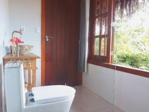 a bathroom with a toilet and a window at Saudade da Bahia in Moreré