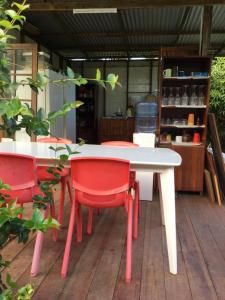 einen weißen Tisch und rote Stühle auf einer Terrasse in der Unterkunft Pension Te Aroha - Te Arii in Maatea