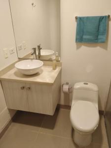 a bathroom with a white toilet and a sink at Hermoso Apto Cartagena in Cartagena de Indias