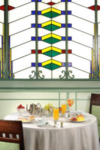 a table with plates of food in front of a stained glass window at Hotel Alexandra in Rome