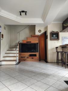 sala de estar con escalera y TV en Cabelera's House en Bombinhas