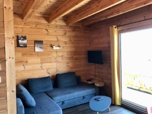 salon z niebieską kanapą w drewnianym pokoju w obiekcie Appart 50m2 4 à 5 pers dans Chalet de charme w mieście Vimines