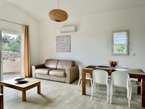 a living room with a dining room table and a couch at Residence Casa Di Paoli in Porto-Vecchio