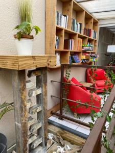 a room with a red chair and a book shelf at Hotel Saint Georges, Face à la mer in Canet-en-Roussillon
