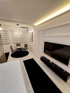 a living room with a large television and a table at A'dors Apartments in Skopje +25 photos