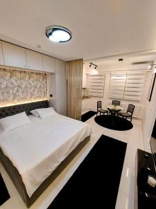ein Schlafzimmer mit einem großen Bett und einem Tisch in der Unterkunft A'dors Apartments - Bed, Breakfast & Spa in Skopje