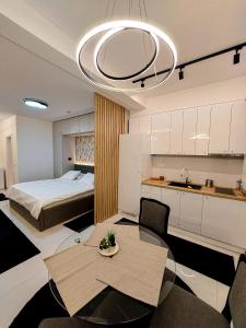 ein Schlafzimmer mit einem Bett und einem Tisch sowie eine Küche in der Unterkunft A'dors Apartments - Bed, Breakfast & Spa in Skopje