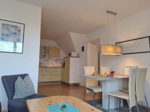 uma sala de estar e cozinha com mesa e cadeiras em Ruhepol am Meer - Apartment mit Balkon em Bastorf