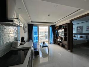 a room with a bed and a kitchen and a living room at Luxury Business Suits in Grand Avenue by Pattaya City Estates in Pattaya Central