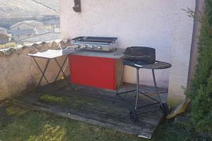 a stove and a grill on a wooden deck at Charmante maison au calme pour 6 personnes in Quincié-en-Beaujolais