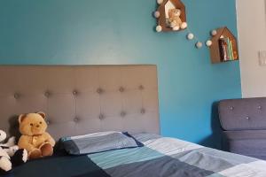 un dormitorio con una cama con animales de peluche en Charmante maison au calme pour 6 personnes, en Quincié-en-Beaujolais