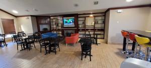 a restaurant with tables and chairs and a flat screen tv at Quality Inn & Suites Columbia I-70 in Columbia