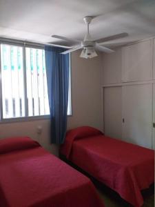1 dormitorio con 2 camas y ventilador de techo en Casa amplia y comoda Godoy Cruz en Godoy Cruz