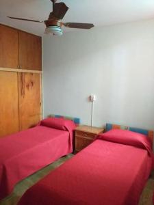2 camas en una habitación con sábanas rojas en Casa amplia y comoda Godoy Cruz en Godoy Cruz