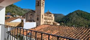 um edifício com uma torre de relógio no topo de um telhado em Casa Rural Ramos em Linares de la Sierra