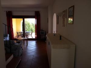a kitchen with a counter and a dining room with a table at Villa Serena B in Stintino