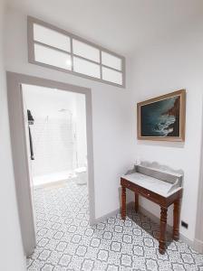Cette chambre blanche dispose d'une table et d'une fenêtre. dans l'établissement La Maison de L' Ambassadeur Carcassonne, à Carcassonne