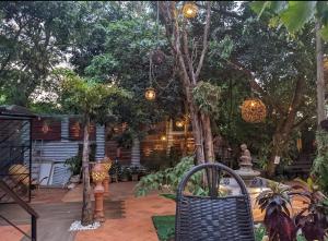 une terrasse avec une table, des chaises et des arbres dans l'établissement Los Monges Aparthotel, à Ciudad del Este