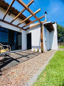 a patio of a house with a wooden pergola at Jardim D’Jully in Santa Terezinha de Itaipu