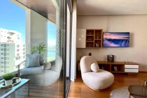 a living room with a chair and a large window at The Panorama of Marina - AppartAli in Casablanca