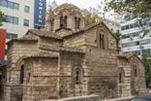 una vieja iglesia de piedra en medio de una ciudad en Metropolis A1-Γοητευτική Σουίτα, en Atenas