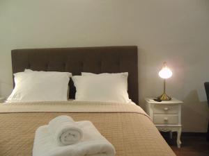 Un dormitorio con una cama con toallas blancas. en Metropolis A1-Γοητευτική Σουίτα, en Atenas