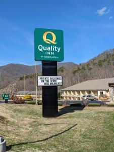 ein Schild für Aquality Inn mit einem Schild für ein Gebäude in der Unterkunft Quality Inn Cherokee in Cherokee