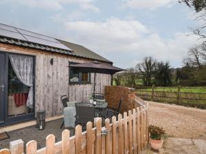 a wooden cabin with a table and a fence at Sunnyside at Coomb Bank Farm in Axminster