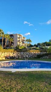 una piscina en el césped con un edificio en el fondo en Entre mar y PortAventura, en Salou