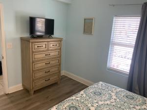 a bedroom with a bed and a television on a dresser at LAKETOWN 5 POOLs STEPS TO BEACH FAMILY FRIENDLY in Panama City Beach