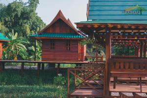 une petite maison en bois avec un toit bleu dans l'établissement เรือนร่มไม้รีสอร์ท RuenRomMai Resort, à Ban Klang Mun