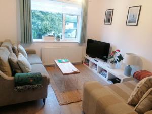 a living room with a couch and a tv at Starboard Side Brixham - Ideal seaside getaway with parking in Brixham