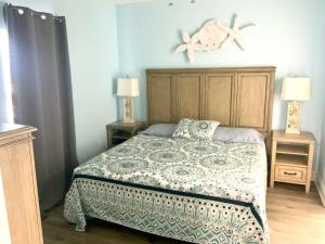 ein Schlafzimmer mit einem Bett und zwei Endtischen mit Lampen in der Unterkunft LAKETOWN 5 POOLs STEPS TO BEACH FAMILY FRIENDLY in Panama City Beach