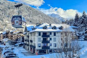 una estación de esquí con un hotel y un remonte en IMMOBILIER DE MONTAGNE - LA COLLECTION - La télécabine, en Saint-Gervais-les-Bains