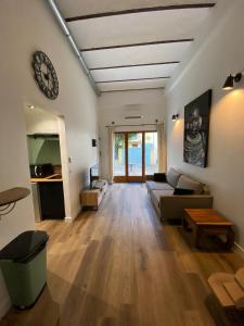 Una sala de estar con un sofá y un reloj en la pared. en Studio côté cour, en Antibes