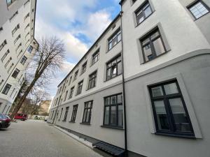 biały budynek z czarnymi oknami na ulicy w obiekcie Dream Apartments - Gdańska 72 w Łodzi