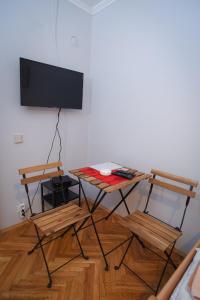 a room with a television and a table and chairs at Vila Balkan in Kikinda