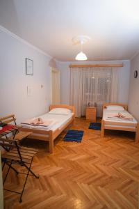 a room with two beds and a wooden floor at Vila Balkan in Kikinda