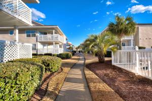 a walkway in front of a house with palm trees at Less Than 1 Mi to Ocean North Myrtle Beach Condo in Myrtle Beach