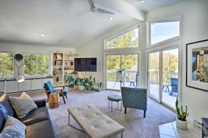 a living room with a couch and chairs and windows at Lakefront Otis Home with Stunning Views and Boats! in Otis