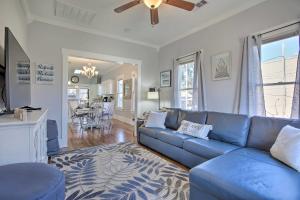 a living room with a blue couch and a dining room at Cozy Beach Bungalow Near Galveston Seawall and Pier in Galveston