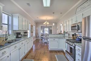 a large kitchen with white cabinets and a counter top at Cozy Beach Bungalow Near Galveston Seawall and Pier in Galveston